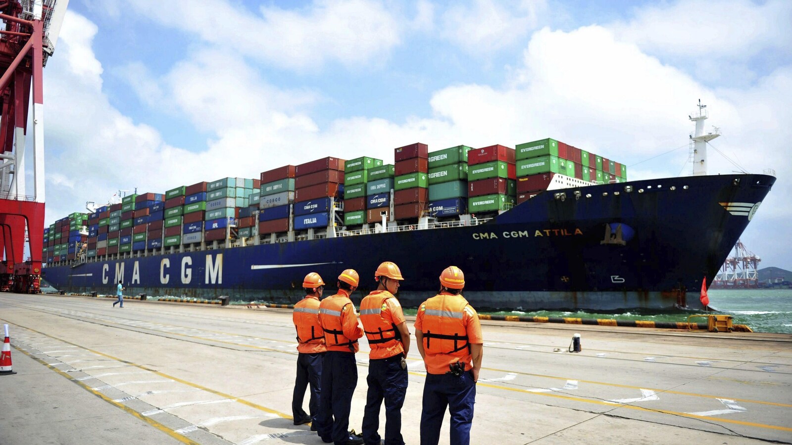 Des débardeurs regardent un bateau sur le quai d'un port chinois.