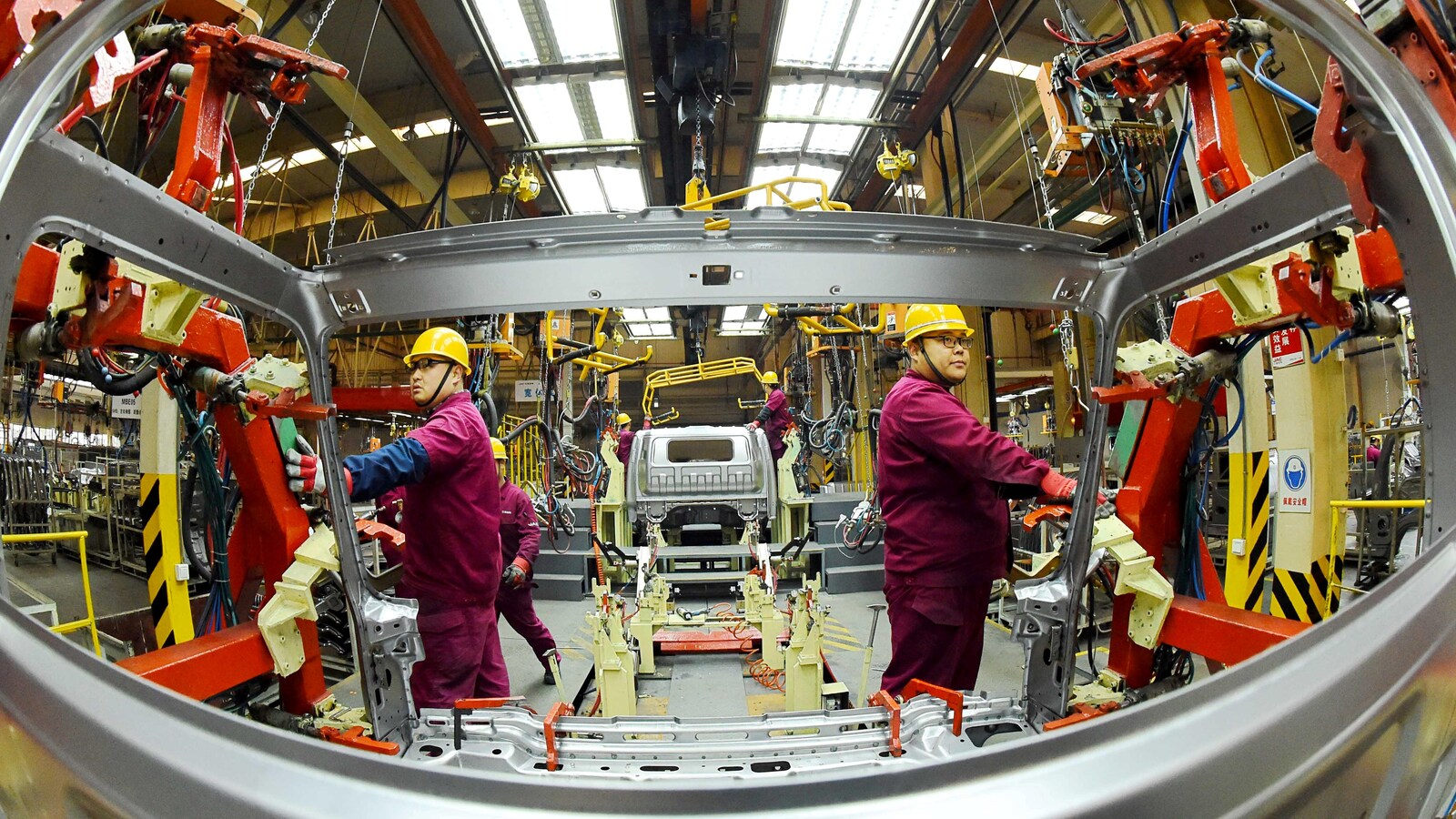 Des employés travaillent sur une chaîne de production fabriquant des camions légers dans une usine de JAC Motors à Weifang, province de Shandong, Chine, le 30 novembre 2018.
