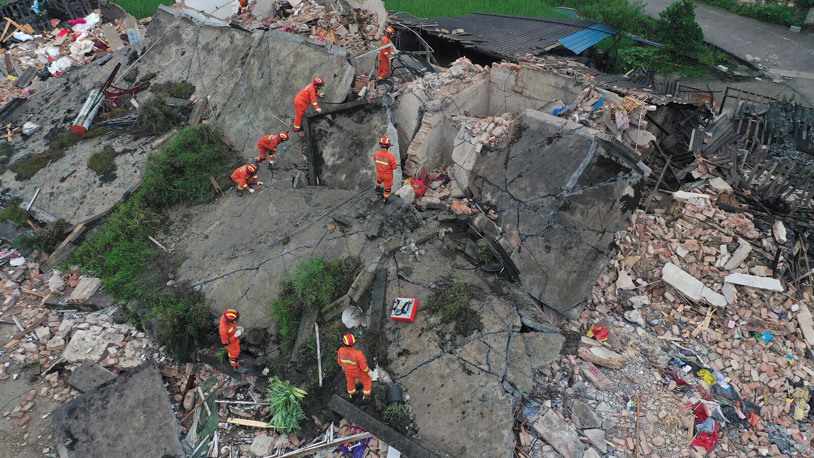 Des hommes cherchent dans un immeuble en ruines.