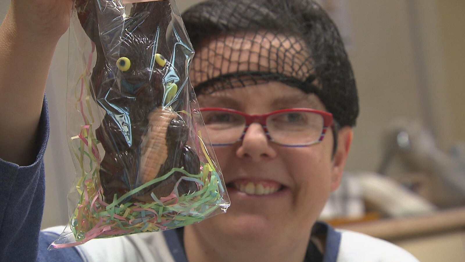 Une femme tient un lapin de Pâques en chocolat