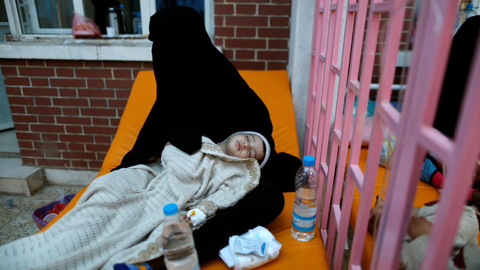 Une femme tient sa fille malade.