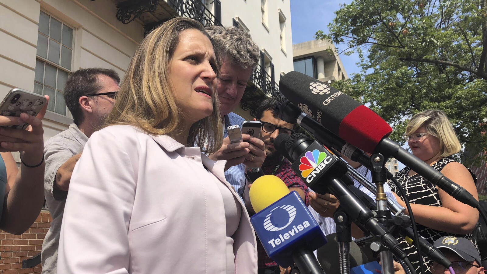 Chrystia Freeland devant une dizaine de micros.