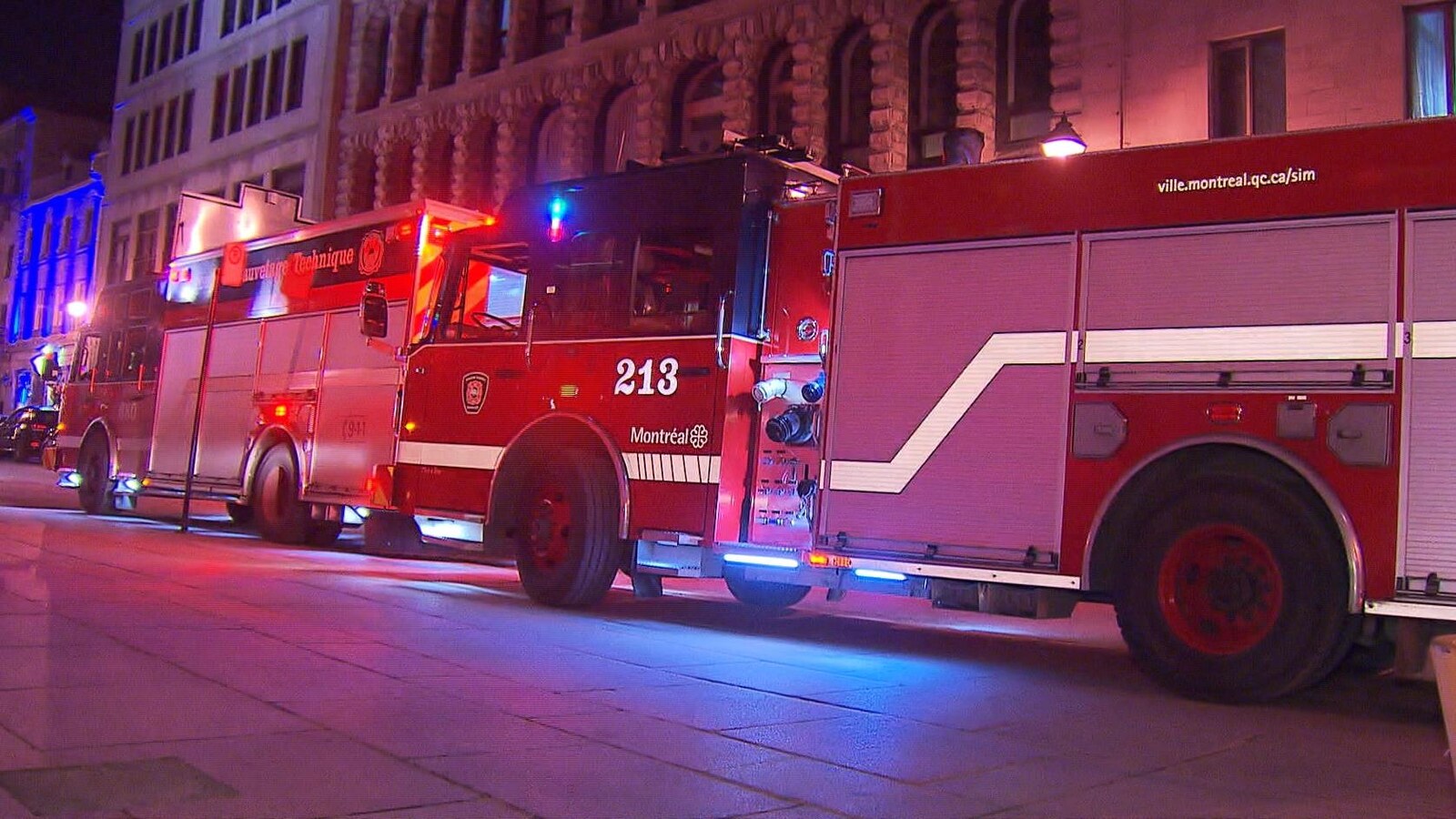 Des camions de pompiers sont stationnés sur une rue.