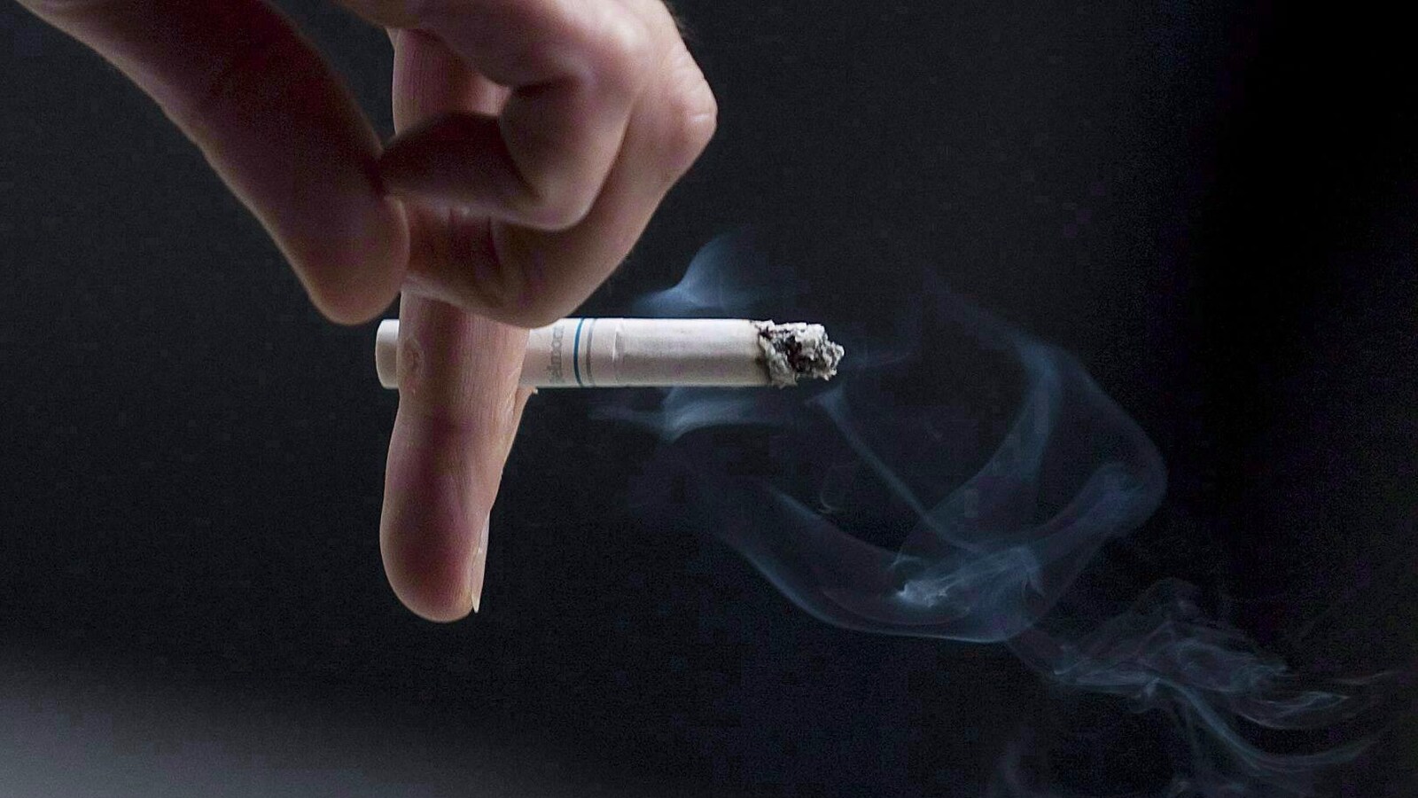 Une main tient une cigarette.