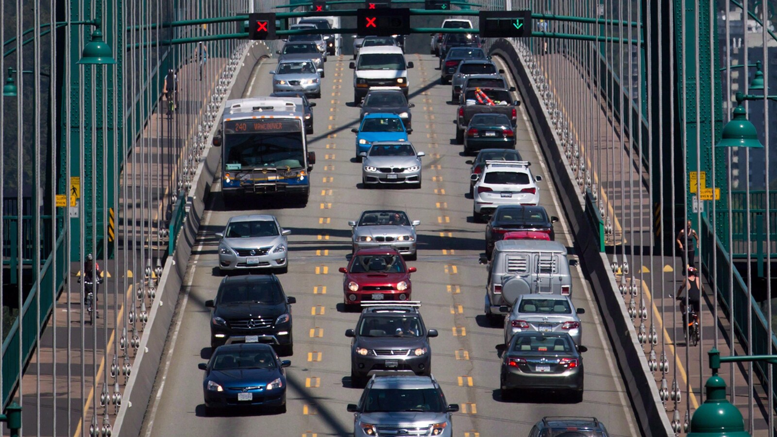 Des voitures, un autobus et des cyclistes traversent le pont Lions Gate.
