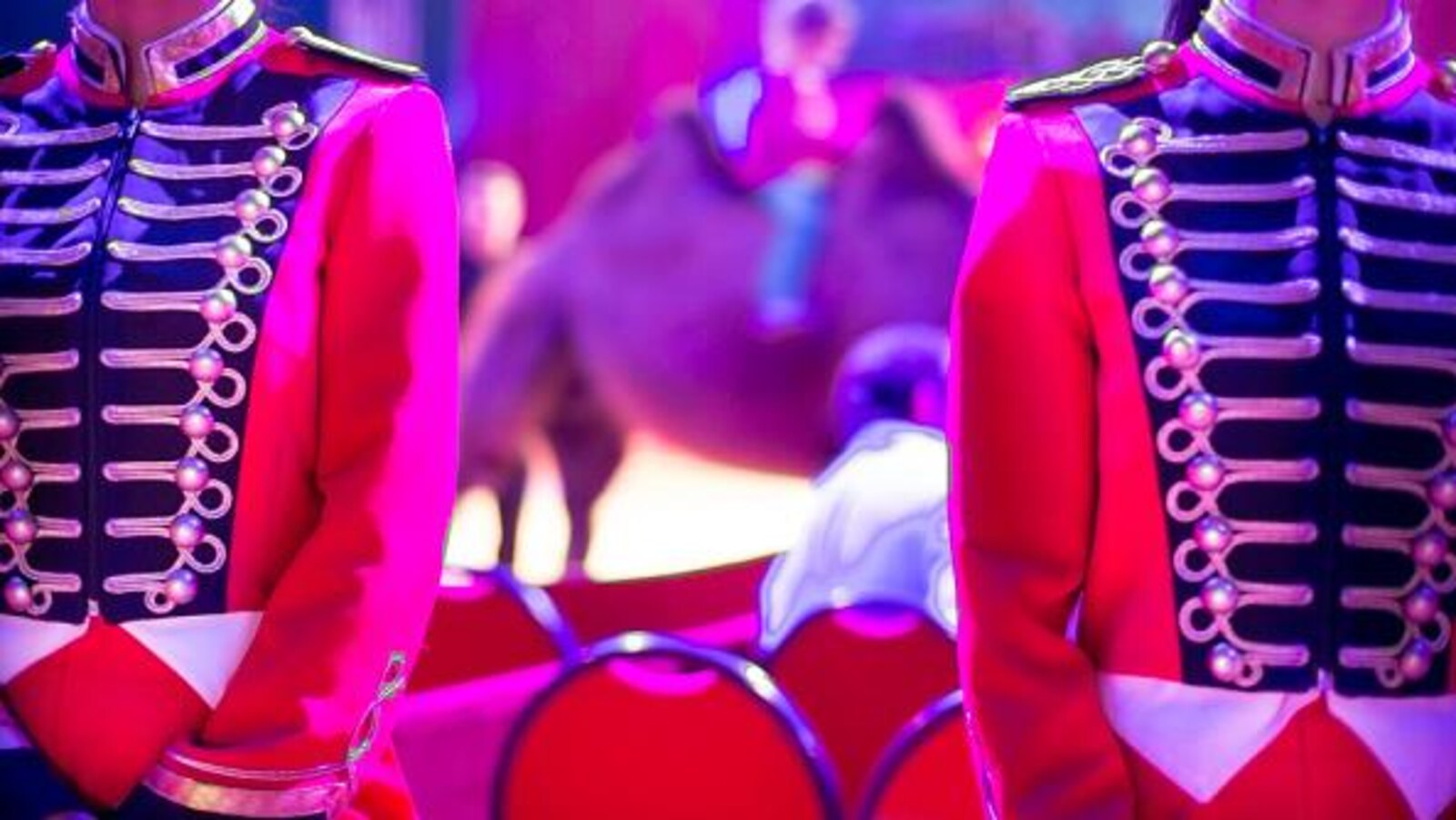 Deux femmes en uniforme accueillent les spectacteurs dans un cirque