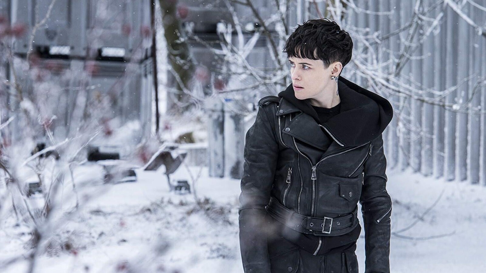 Claire Foy regarde sur le côté tout en marchant ans la neige.