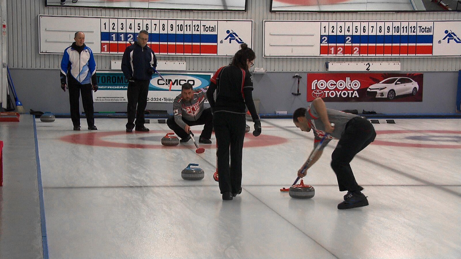 Plusieurs personnes jouent au curling.