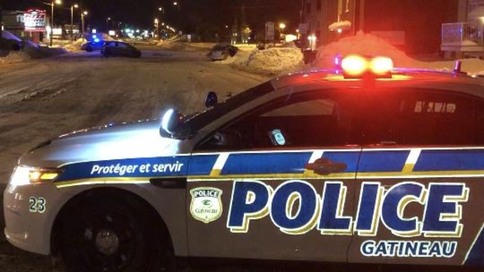 Une voiture de police bloque le chemin.