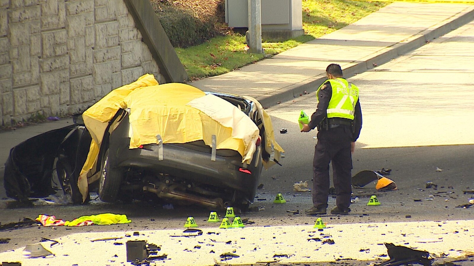 Une voiture écrasée recouverte d'une bâche en plastique jaune.