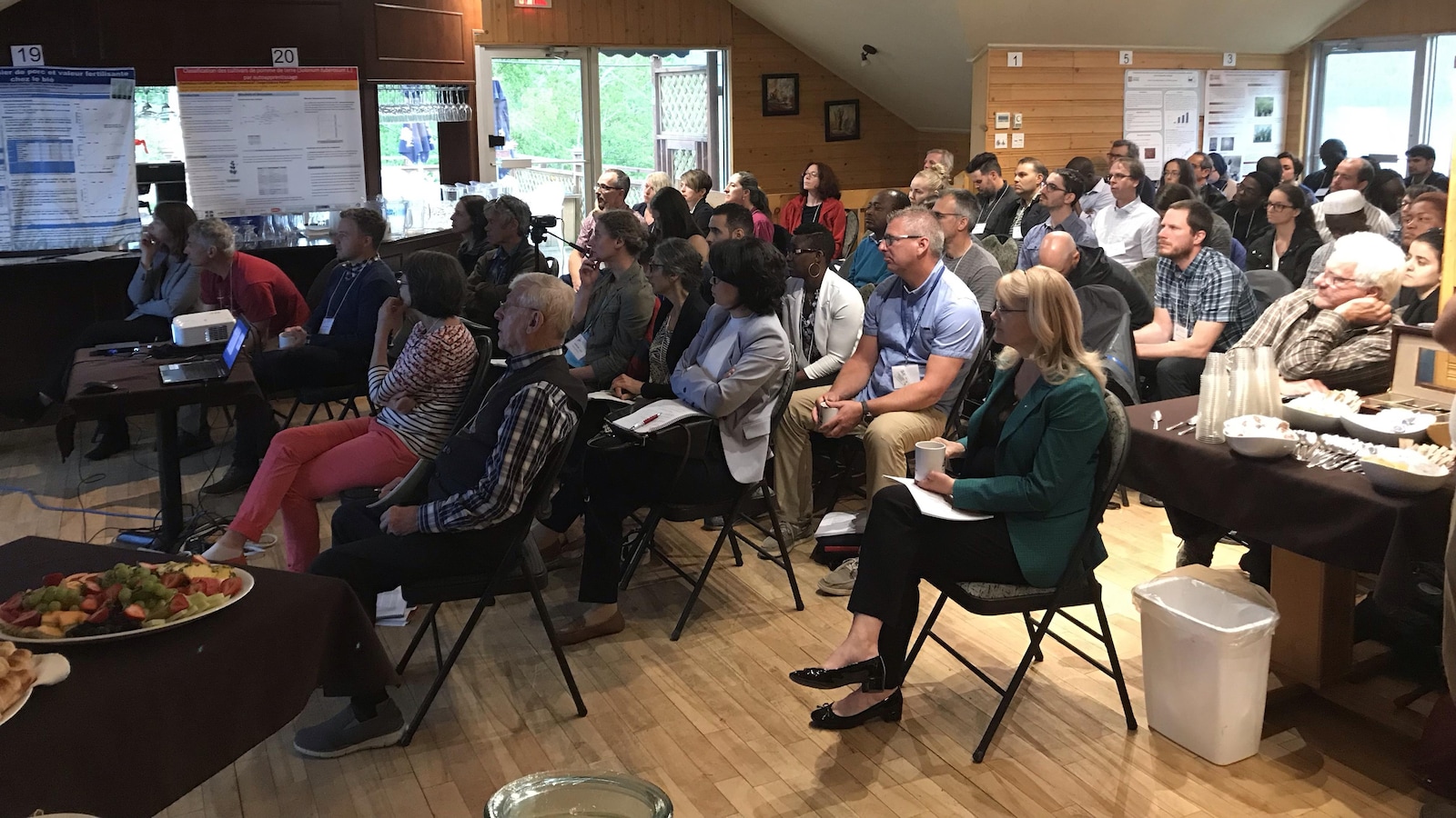Quelques dizaines de gens écoutent une présentation lors d'un colloque.