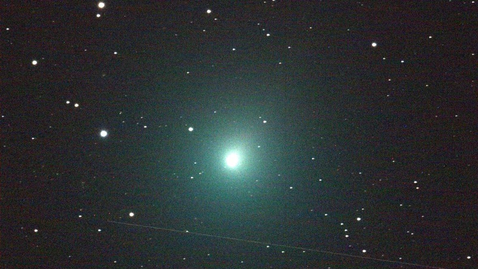 Une comète brille au centre d'un ciel étoilé.