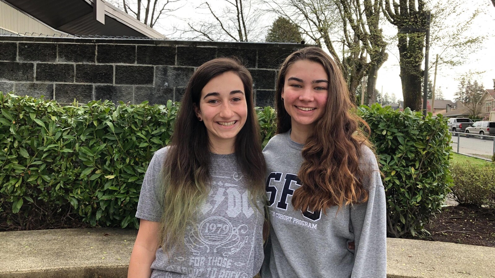 Deux jeunes femmes aux cheveux longs et souriantes posent pour la photo.