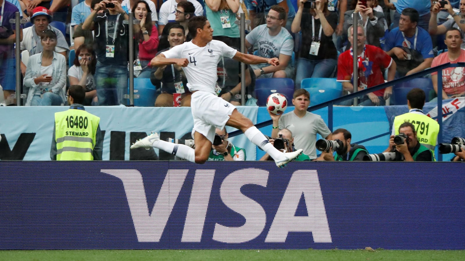 La marque VISA est affichée sur la bordure du terrain de soccer d'un stade.
