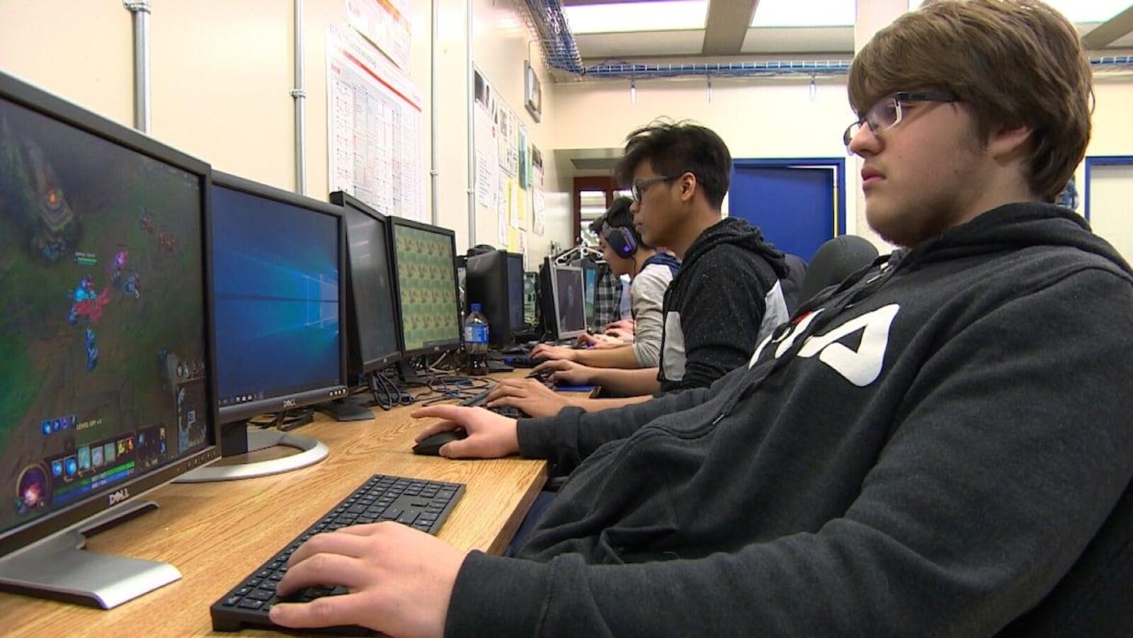 Des jeunes jouent à des jeux vidéos dans une salle de classe.