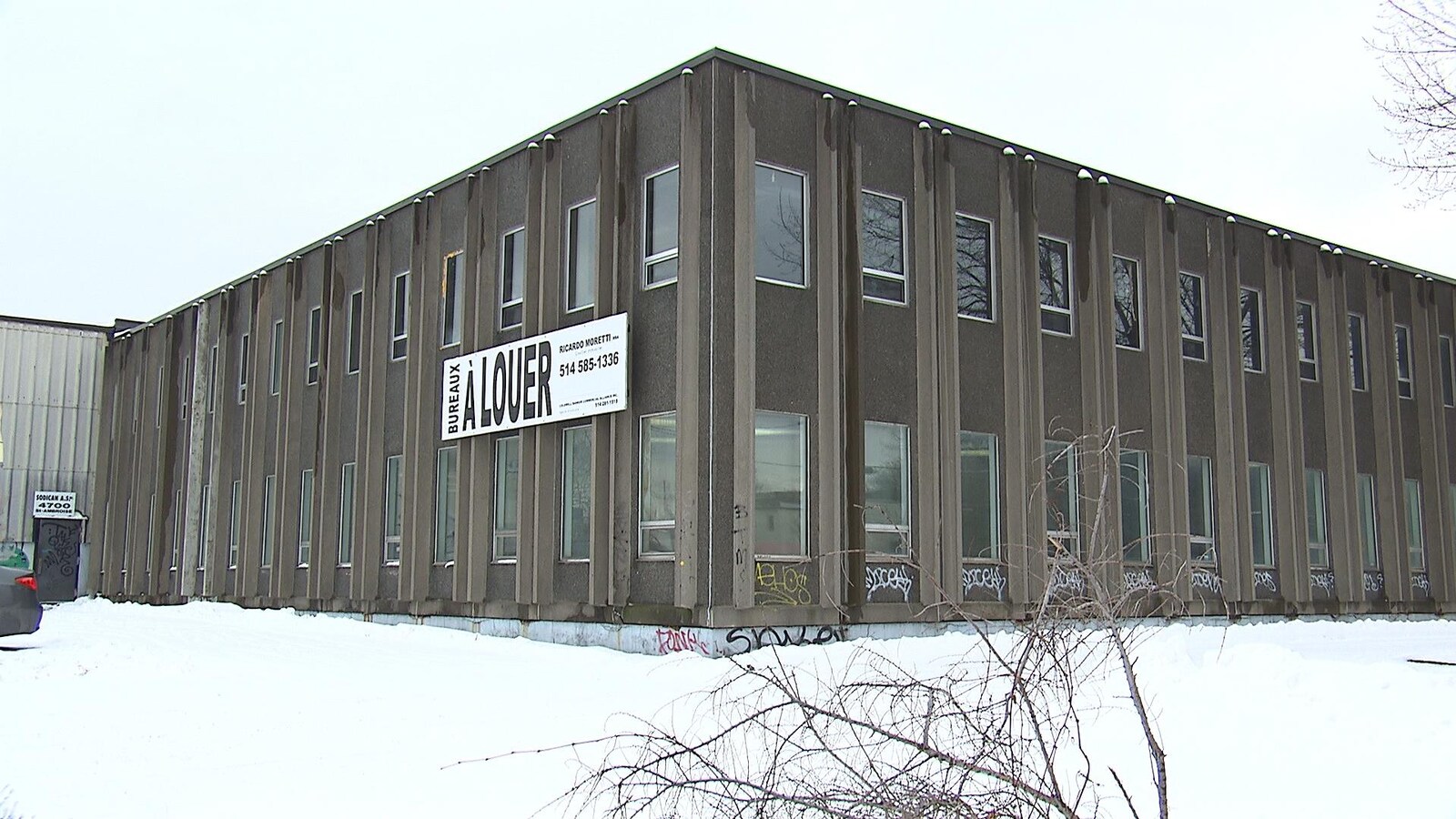 Un édifice vieillot avec une affiche « bureaux à louer ».
