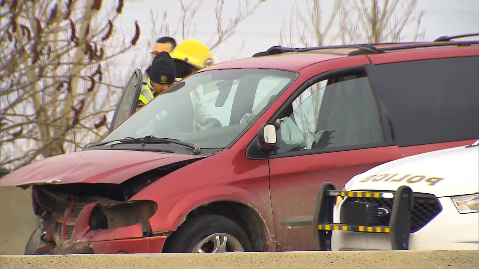 Des policiers et pompiers examinent une fourgonnette à l'avant violemment accidenté.