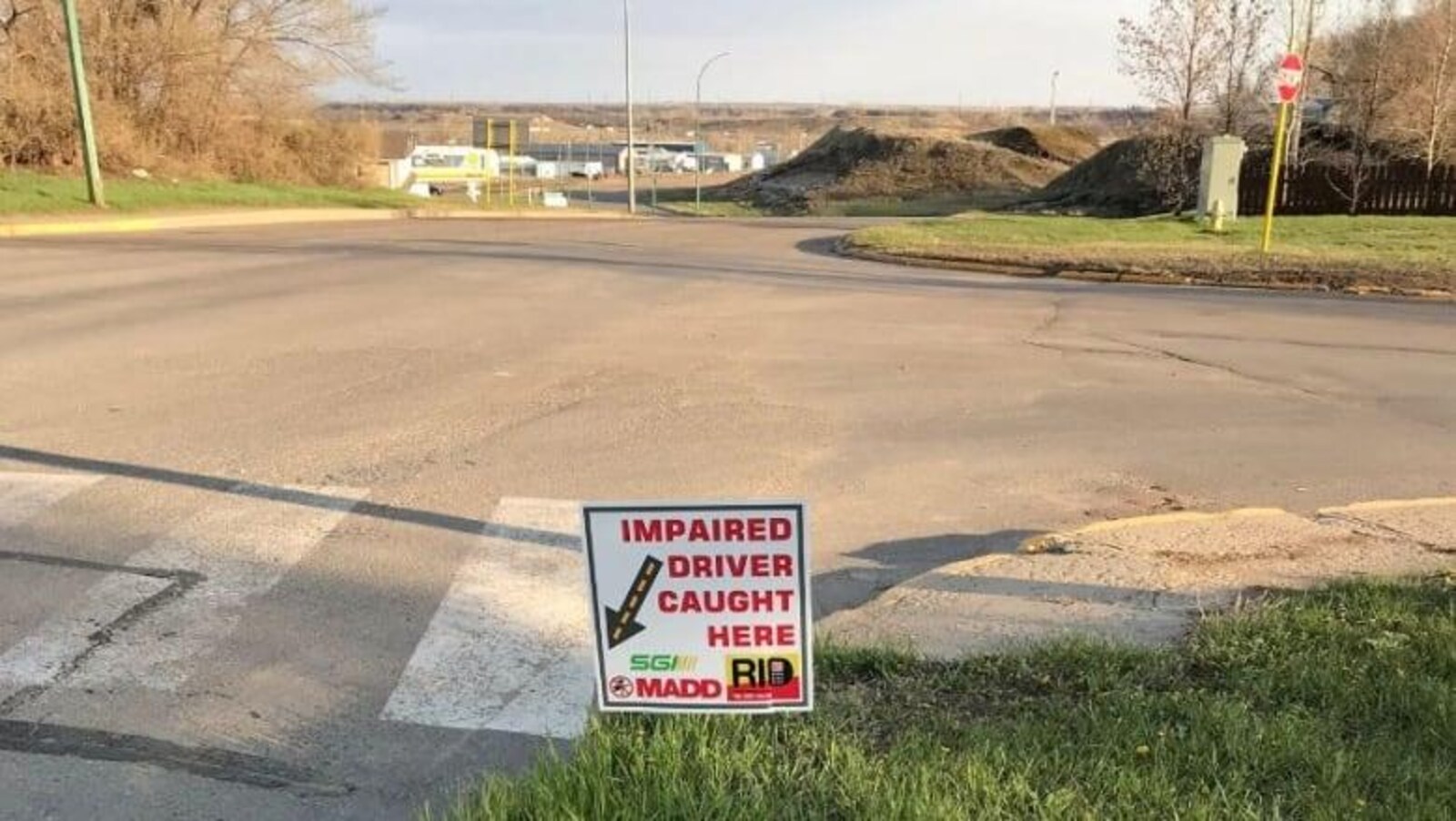 Un des écriteaux installés au ras du gazon près d’une intersection.