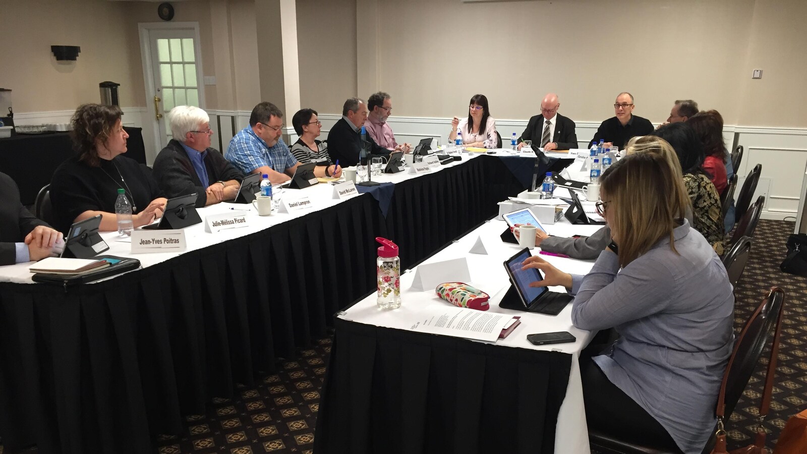Des membres sont réunis autour d'une table de réunion.