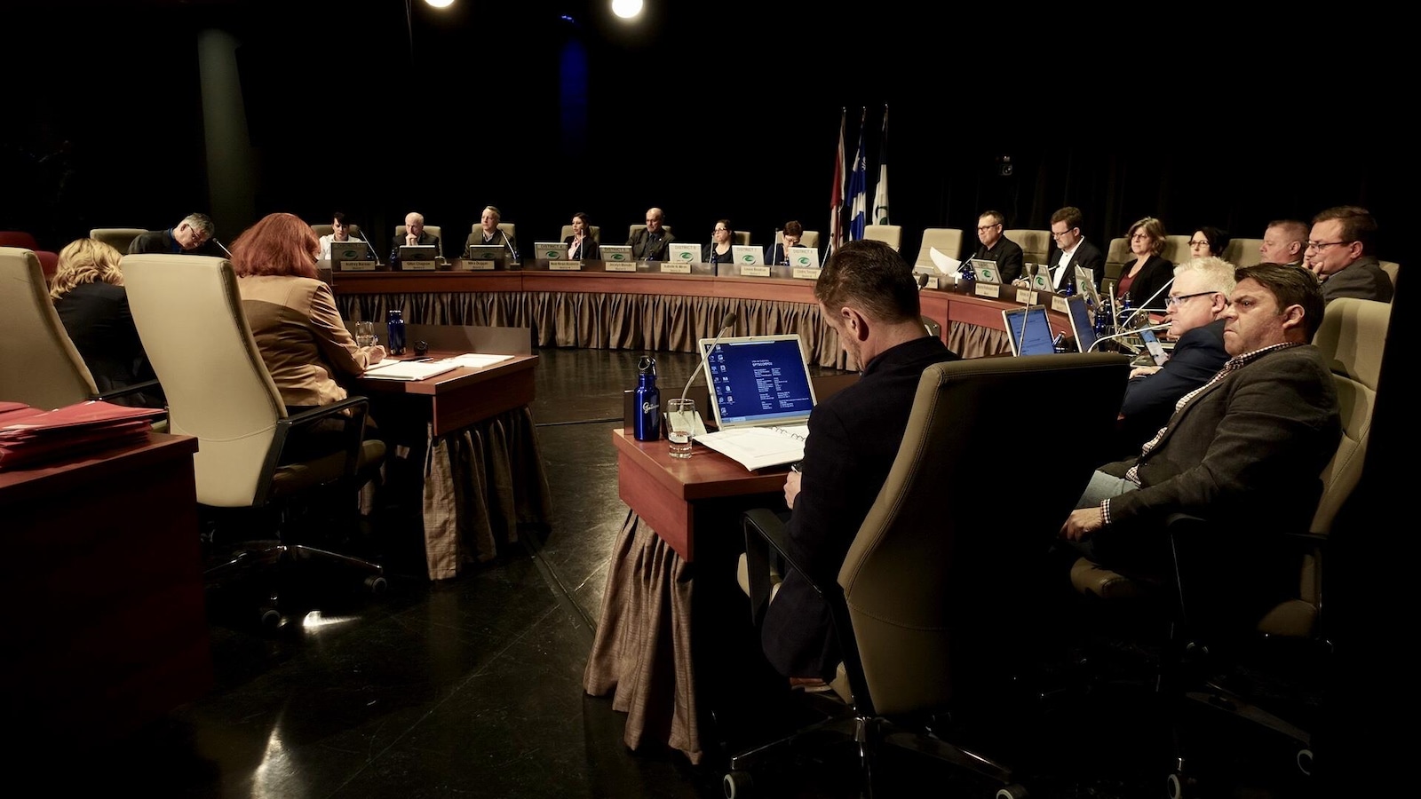 Des politiciens assis autour d'une grande table en forme de demi-cercle.