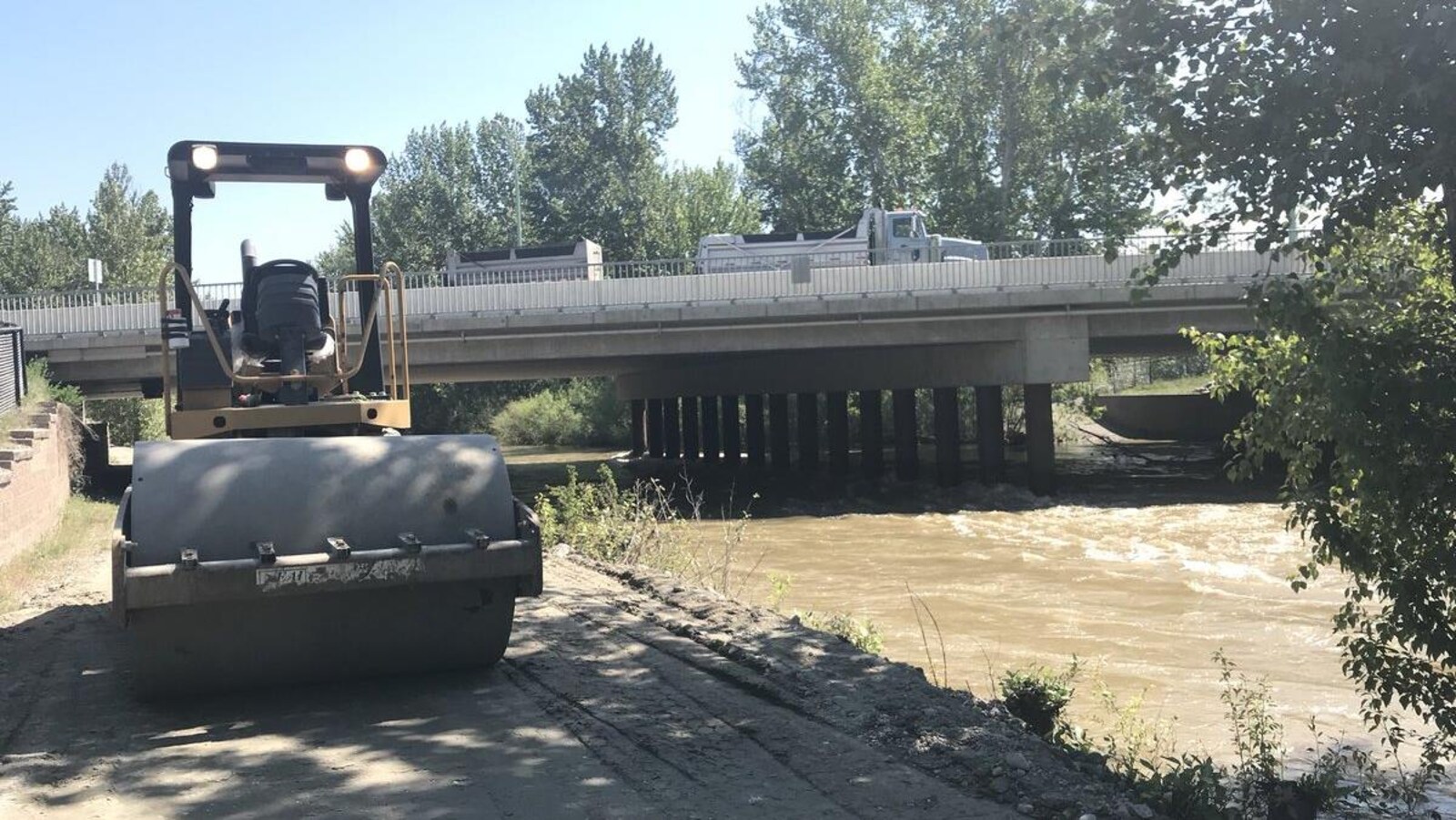 Un camion de construction stationné le long d'un ruisseau.