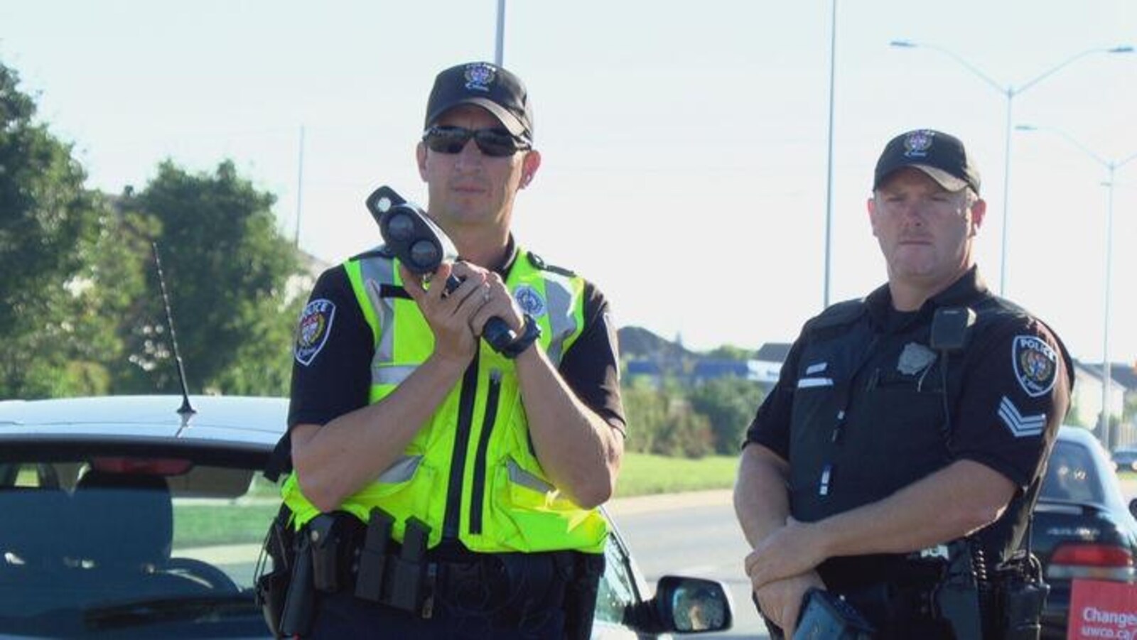 Le policier tient un radar dans ses mains le long d'une rue d'Ottawa