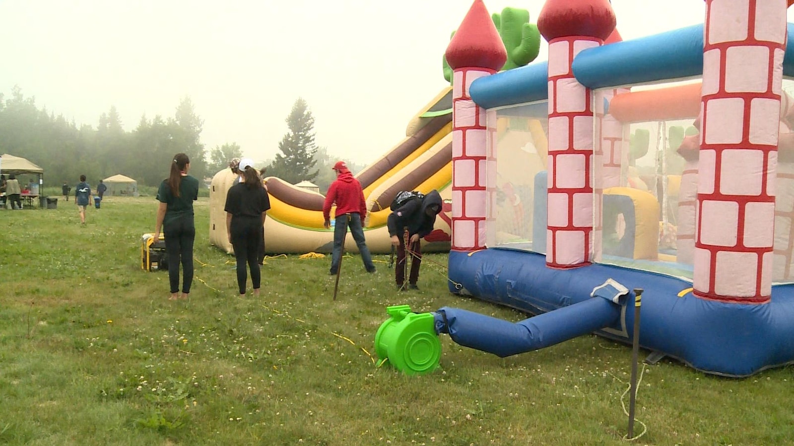 Des adolescents qui travaillent à fixer des jeux gonflables.