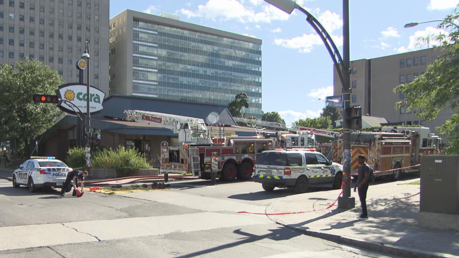 Des véhicules de police et des services incendie devant un restaurant qui a été la proie des flammes.