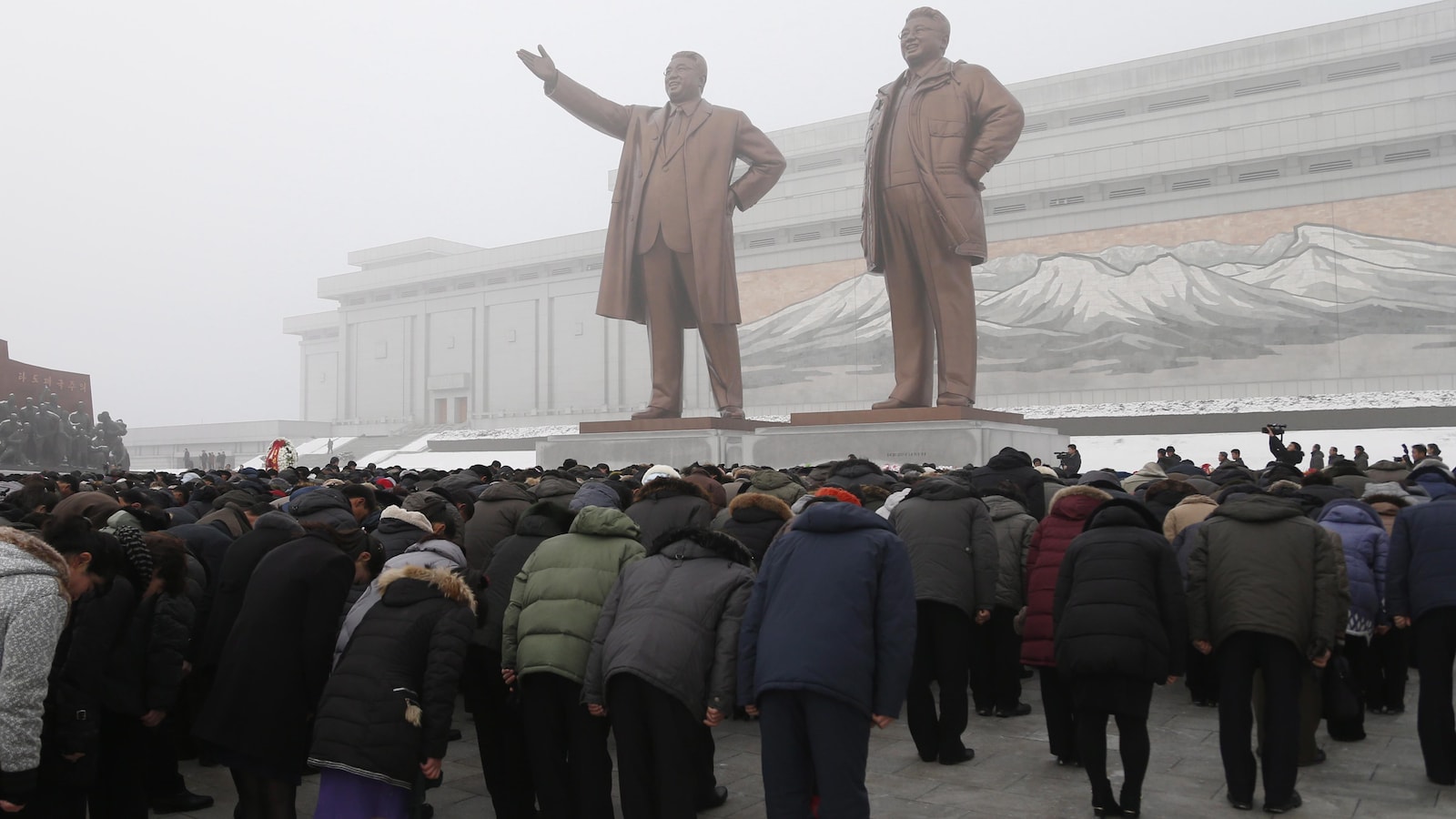 Les Nord-Coréens saluent deux statues de bronze représentant d'anciens leaders du pays Kim Il Sung et Kim Jong-il.