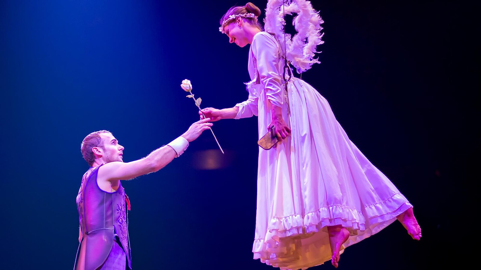Le clown Mauro donne une rose à une autre artiste dans son costume d'ange.