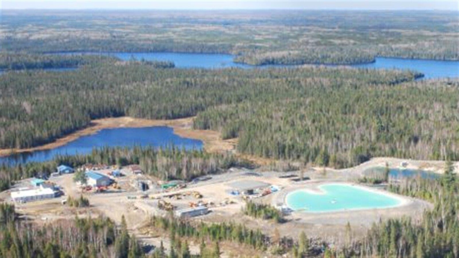 Vue aérienne d'un camp de travailleurs minier entouré de forêt boréale.