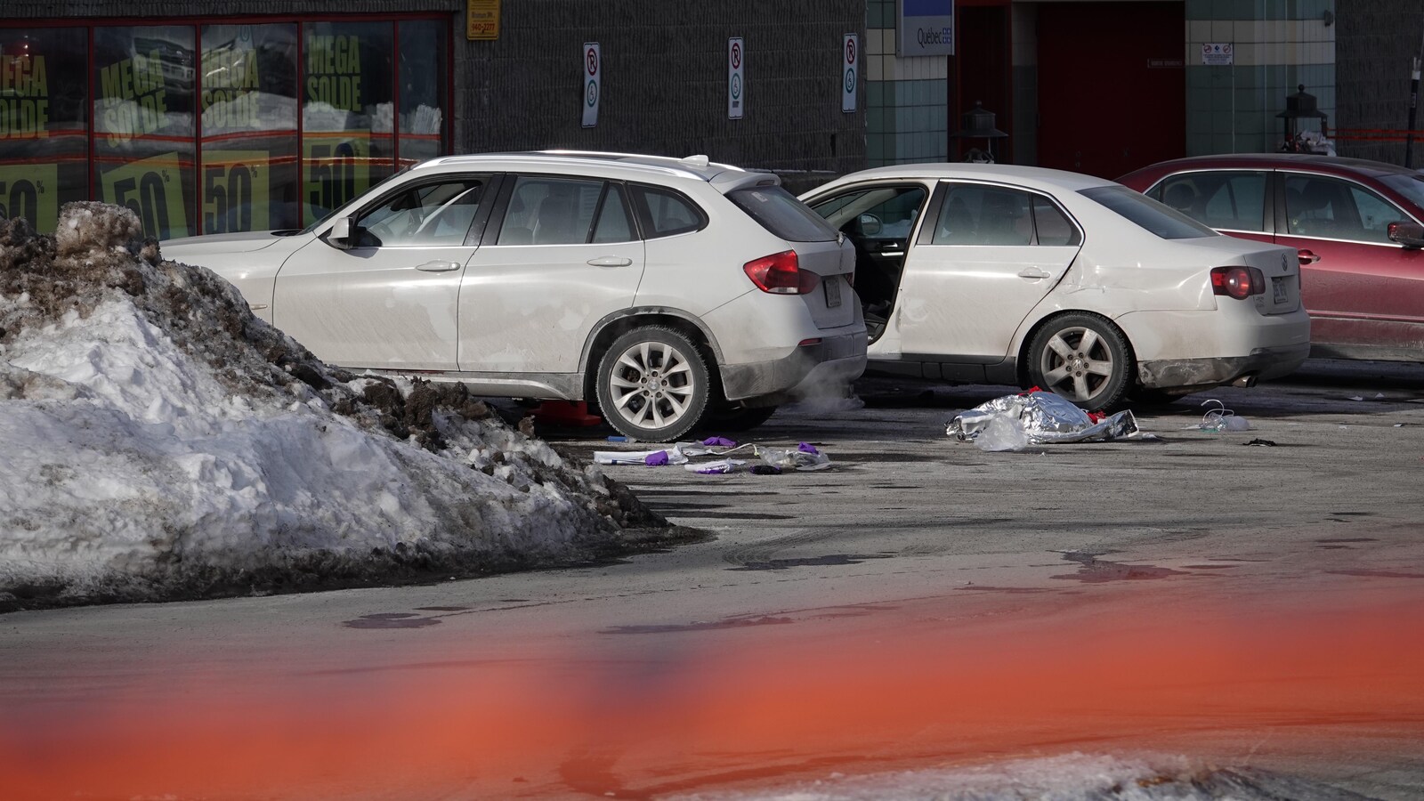 Dans un stationnement, une voiture a la porte grande ouverte du côté du conducteur.