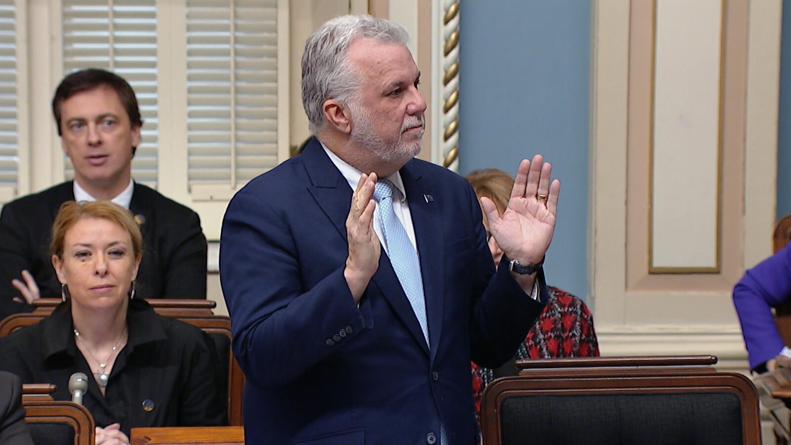 Le premier ministre du Québec Philippe Couillard est debout avec les deux mains levées devant lui. Il répond à l'opposition officielle, lors de la période de questions mercredi à Québec.