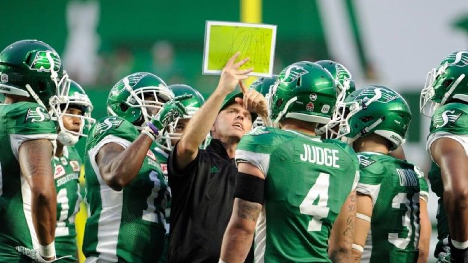 Craig Dickenson entouré des joueurs des Roughriders.