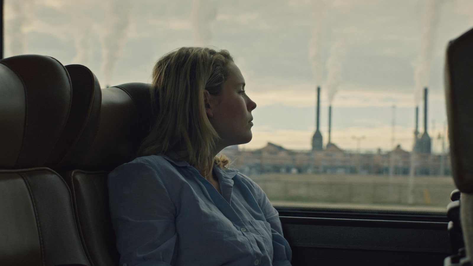 Une actrice sur un banc d'autobus, elle regarde par la fenêtre.