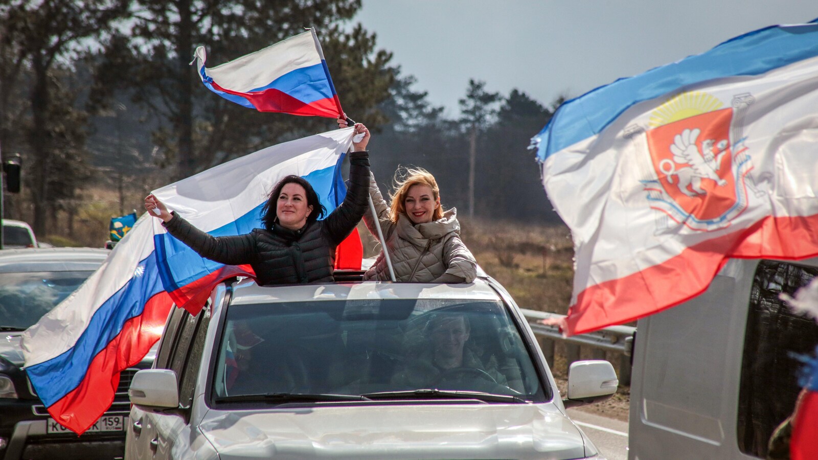 Des femmes brandissent le drapeau russe à Sébastopol, port d'attache de la flotte de la mer Noire, où est attendu le président russe, Vladimir Poutine, lundi.