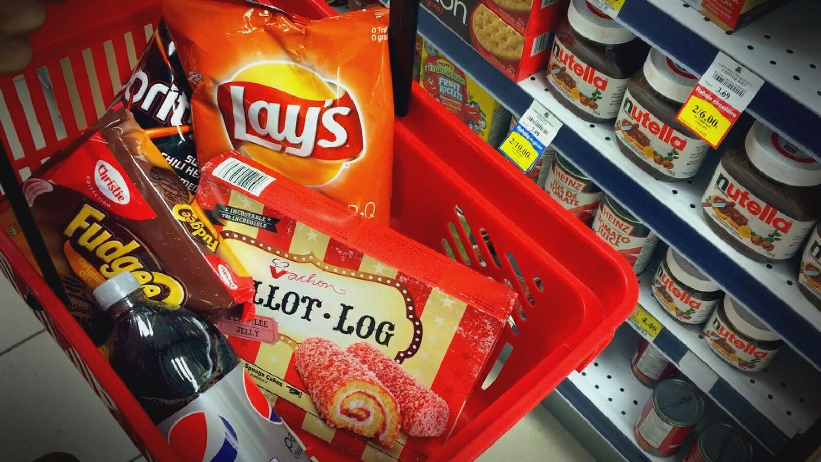 On voit un sac de croustilles, une bouteille de boisson gazeuse et des boîtes de gâteaux vendus en pharmacie.