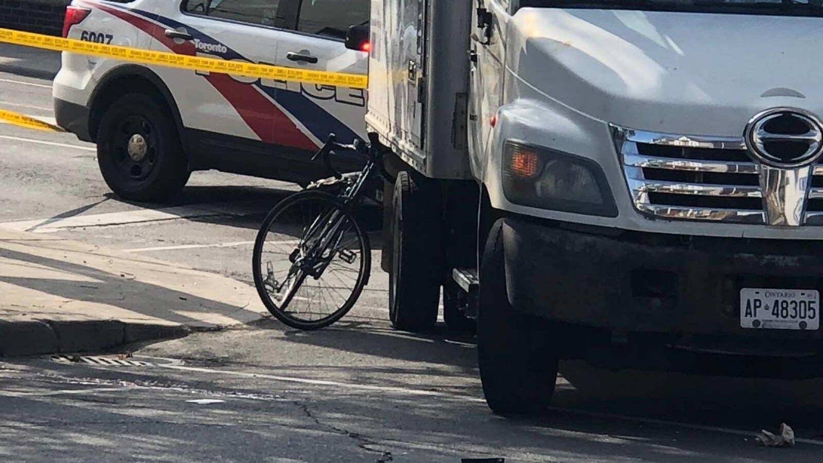 Photo d'un vélo coincé sous un camion blanc