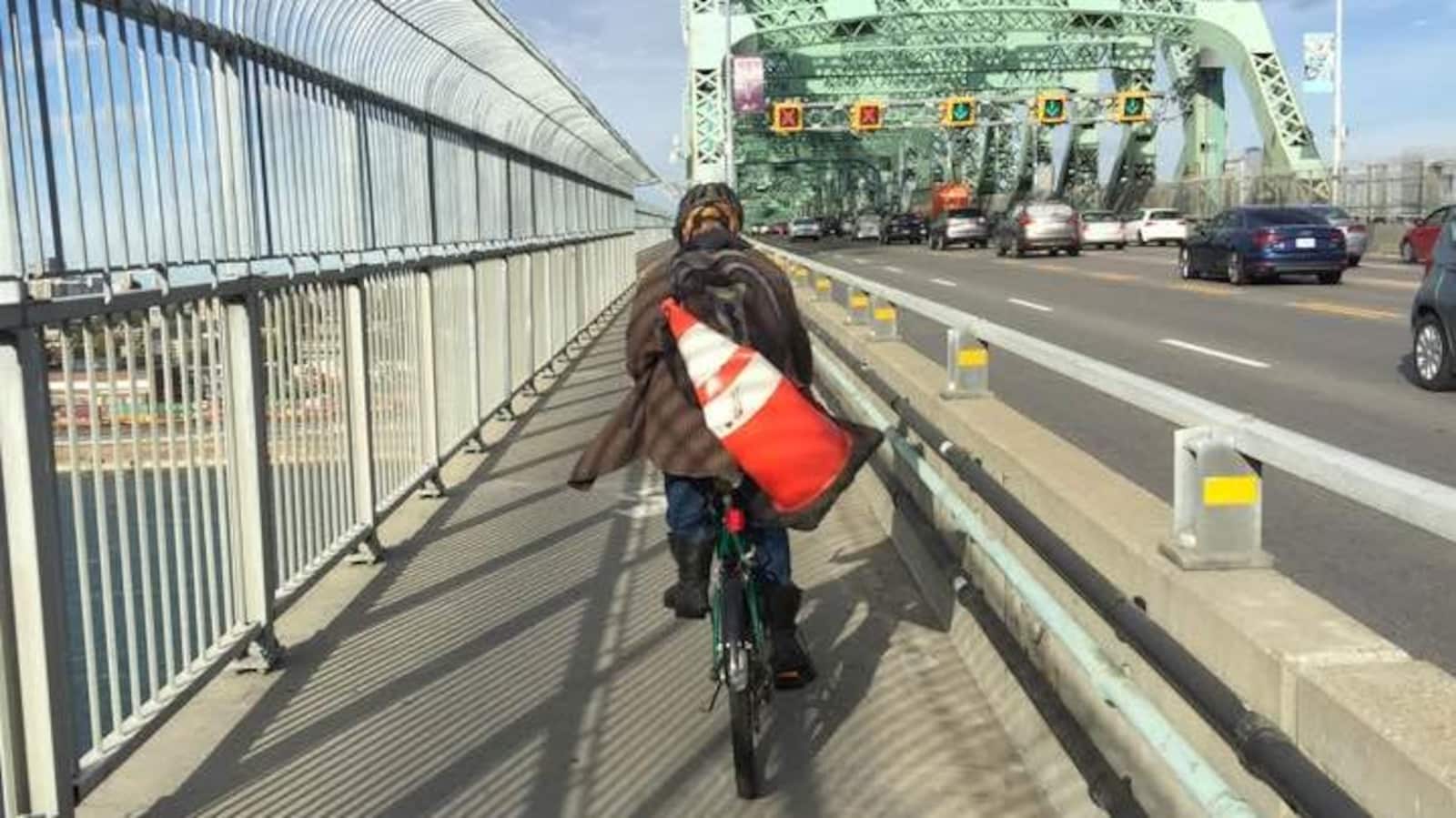 Un cycliste roule sur la piste multifonctionnelle du pont Jacques-Cartier, entre l'île de Montréal et la Rive-Sud.