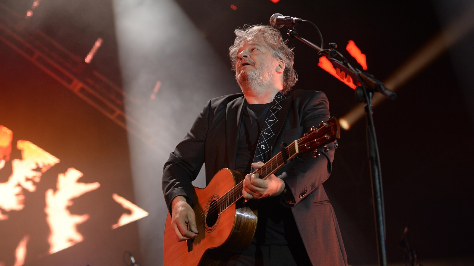 Daniel Bélanger jouant de la guitare sur scène lors de son concert aux Francos de Montréal, le 12 juin 2018.