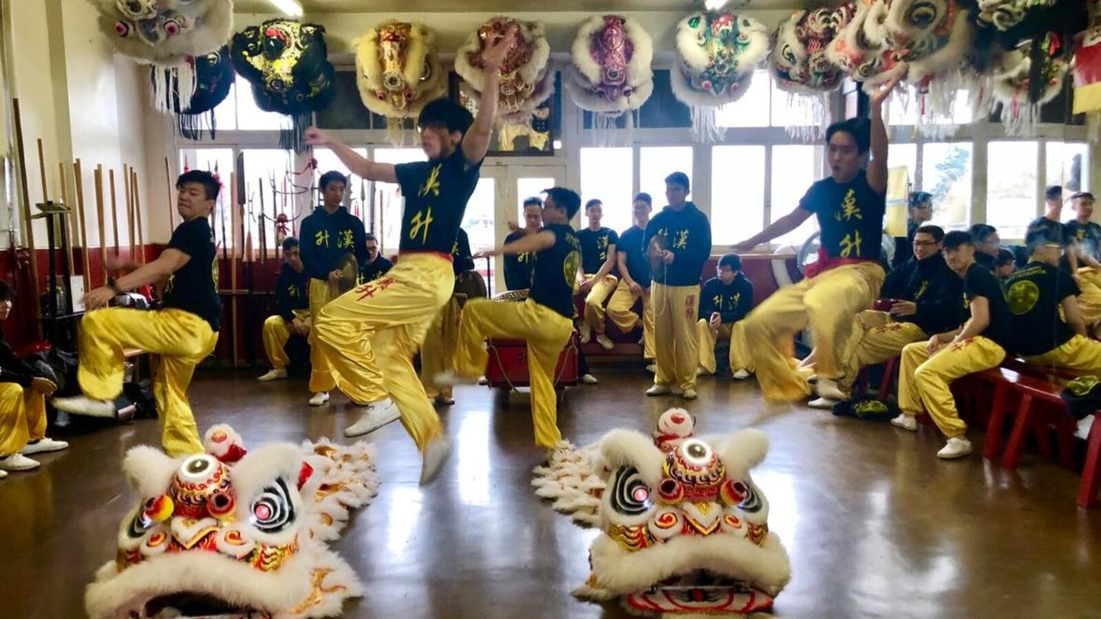 Des jeunes effectuent un saut dans le studio de danse, lors d'une répétition