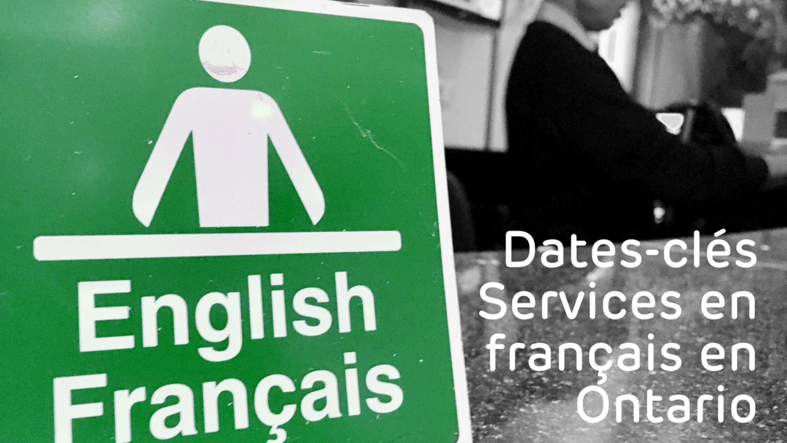 Photo d'un écriteau English / Français sur un comptoir avec un préposé