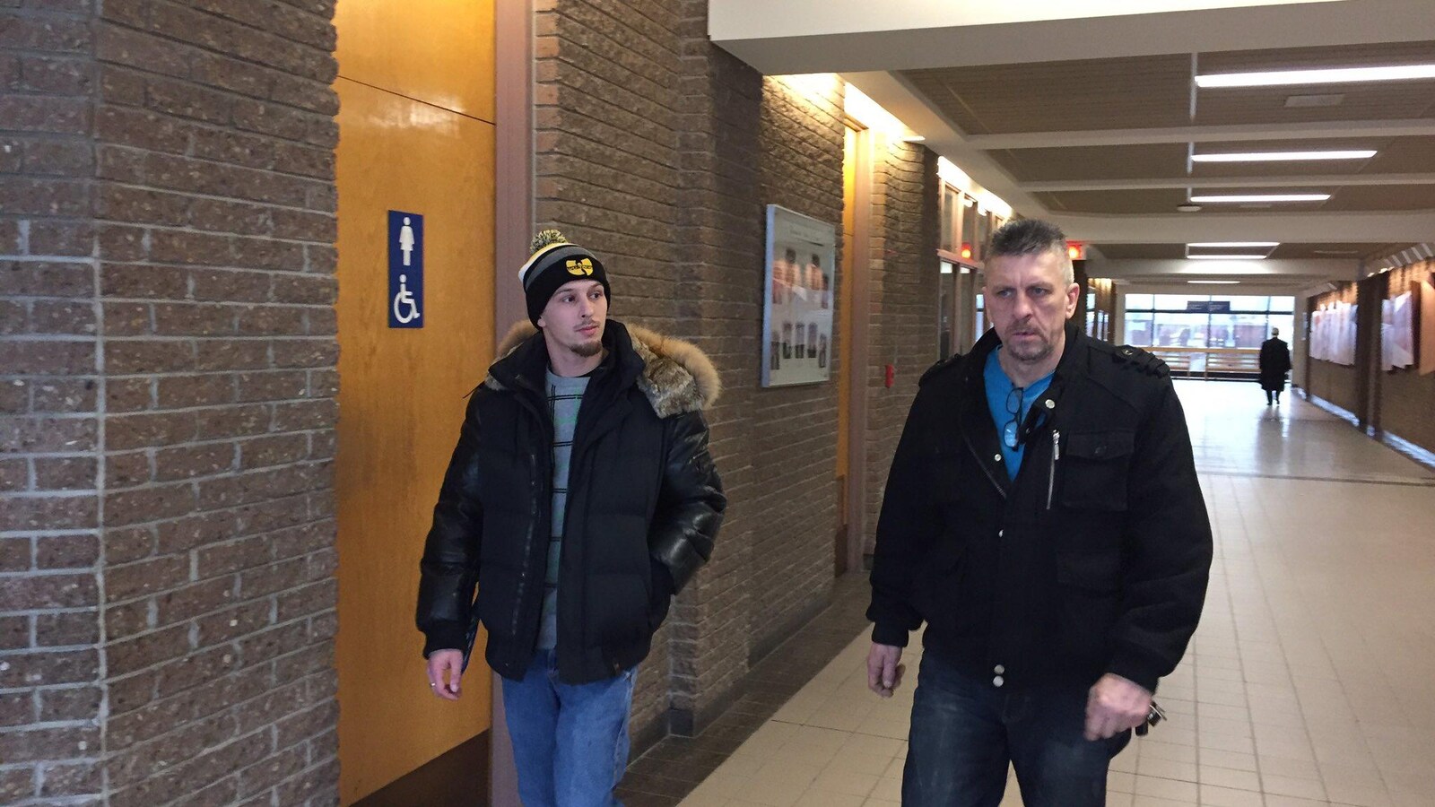 Dave Poulin-Beaunoyer (à gauche) à son arrivée au palais de justice.