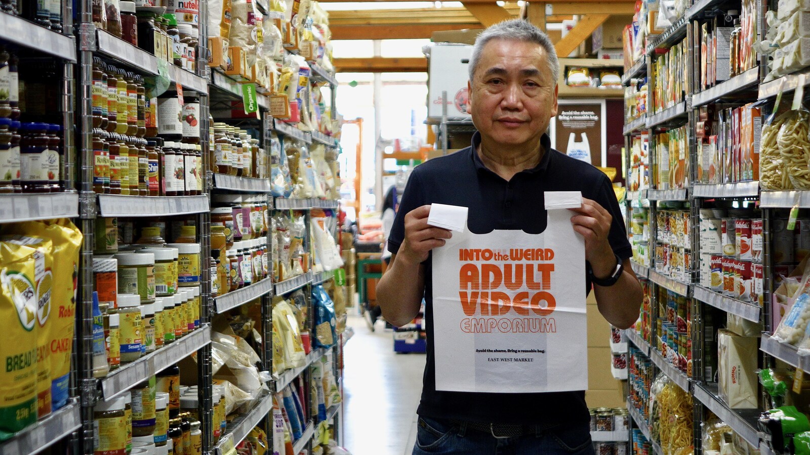 Un homme tient un sac en plastique devant lui pour la photo.