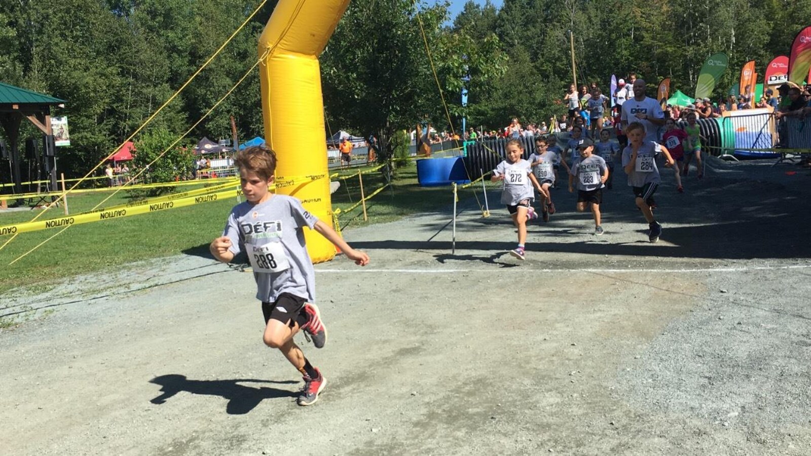 Un enfant traverse la ligne d'arrivée au 6e Défi du parc de la rivière Gentilly.
