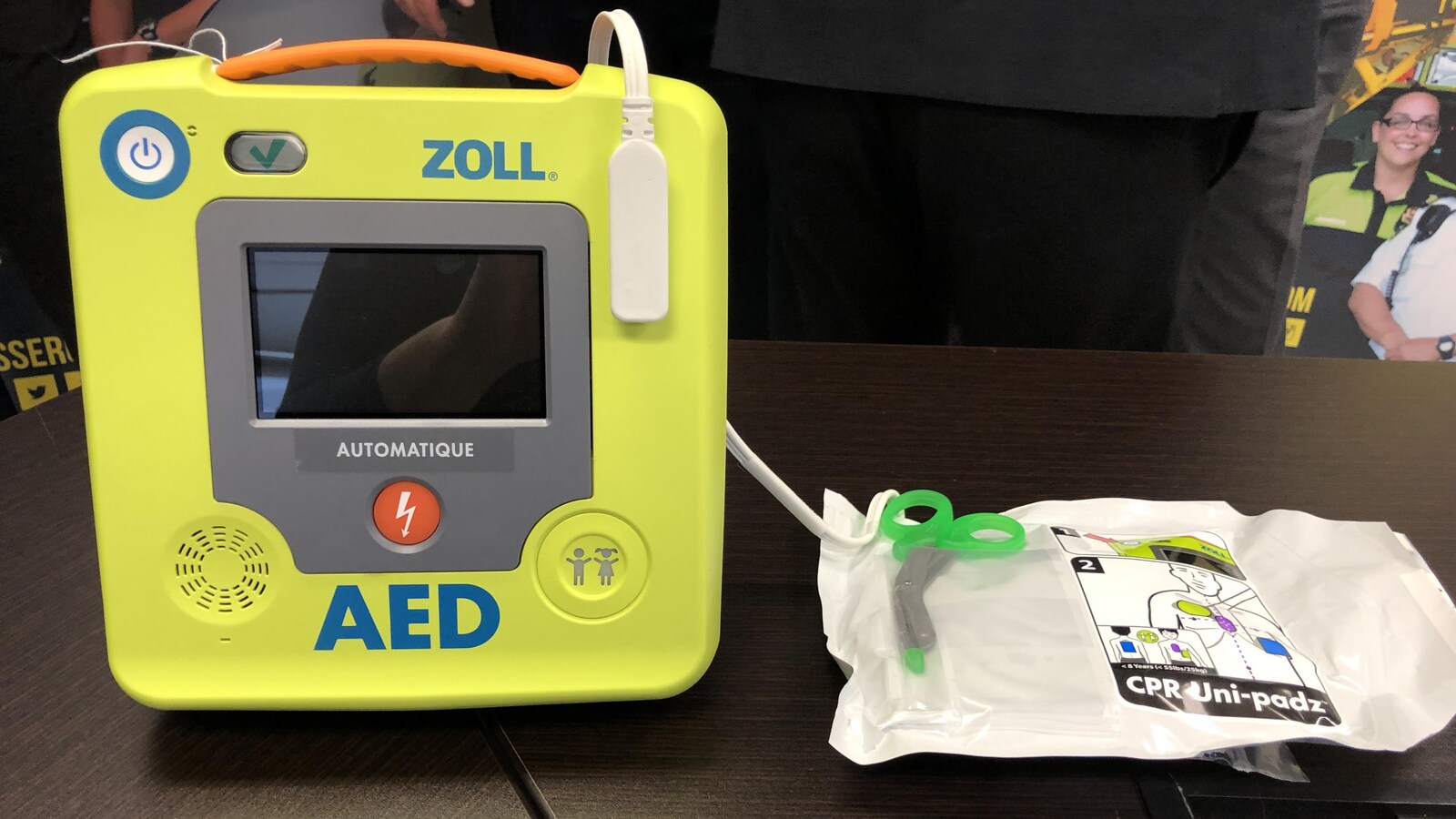 Un défibrillateur cardiaque automatique est posé sur une table.