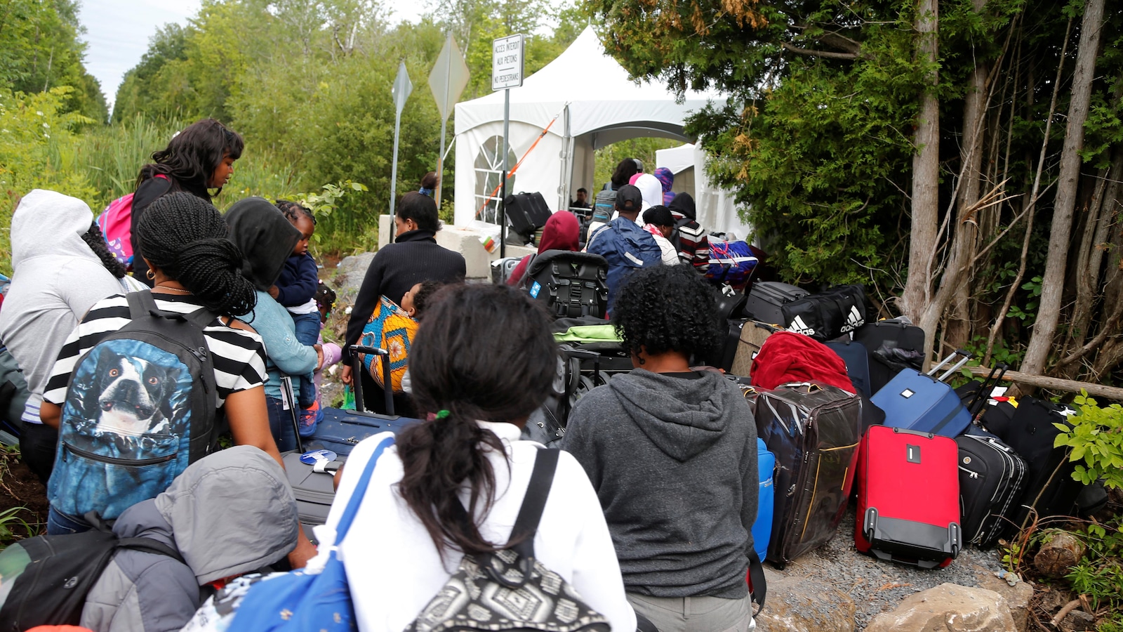 Cette photo prise en août dernier montre une file de demandeurs d'asile qui attendent de franchir un point de contrôle installé au bout du chemin Roxham, à Saint-Bernard-de-Lacolle.