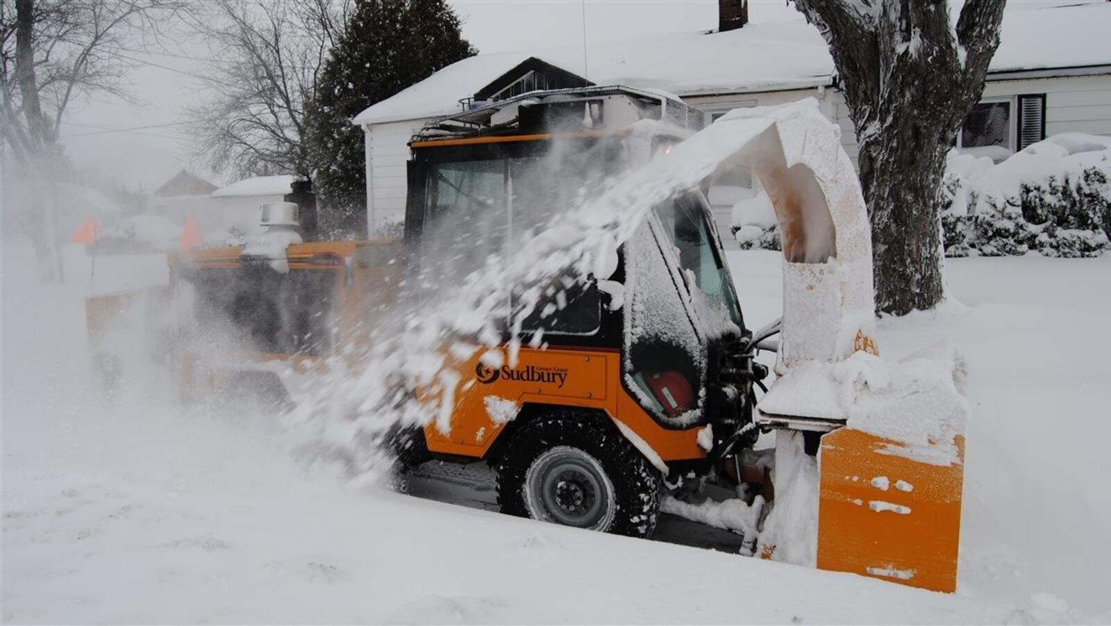 Une déneigeuse à trottoir en action.