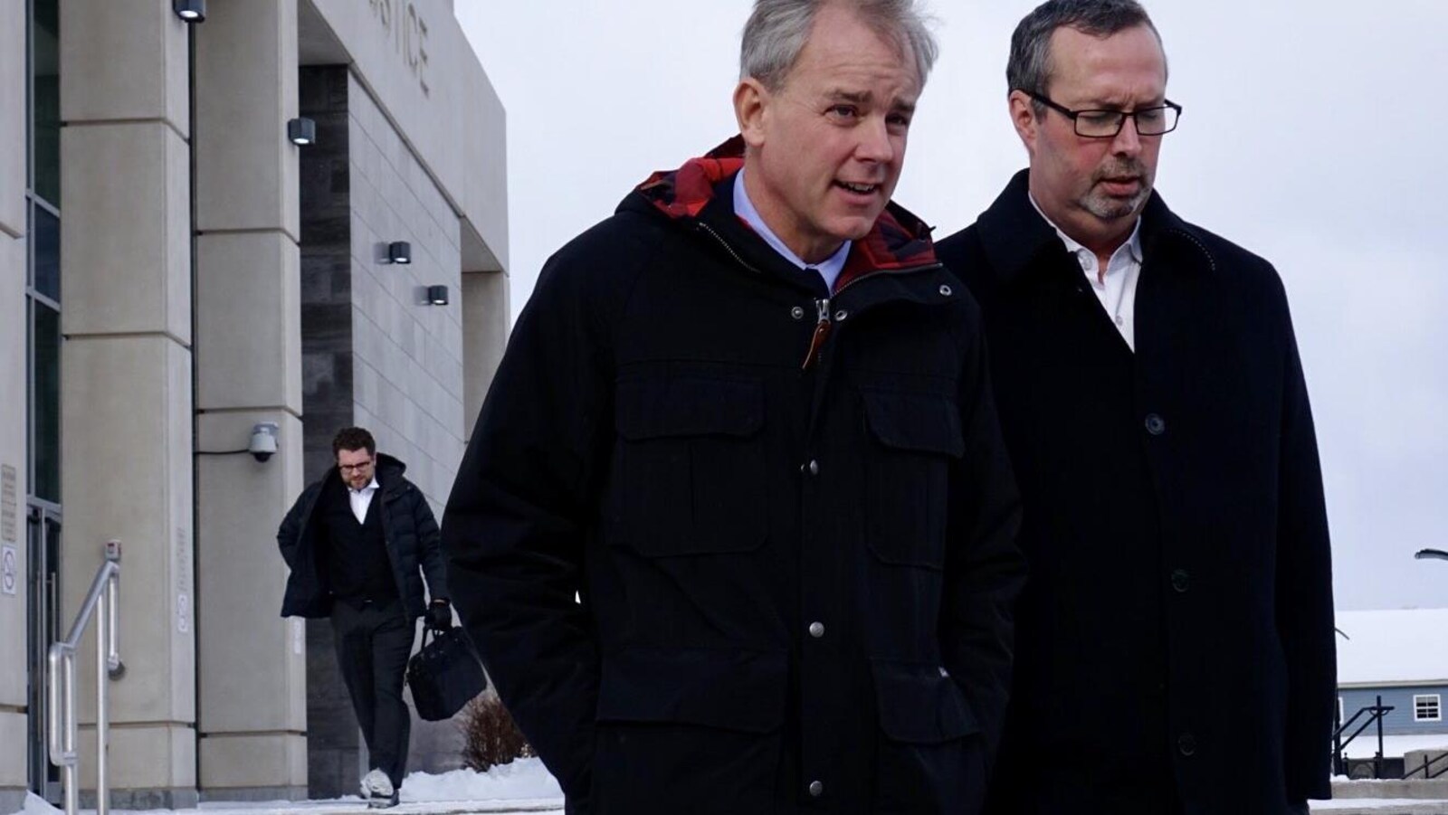 Dennis Oland qui quitte le palais de justice de Saint-Jean aux côtés de son avocat.
