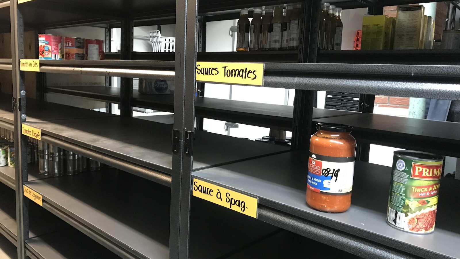 Des tablettes de la Banque alimentaire Memphrémagog sont vides. Il manque de conserves de sauce tomates, de tomates broyées et bien plus.